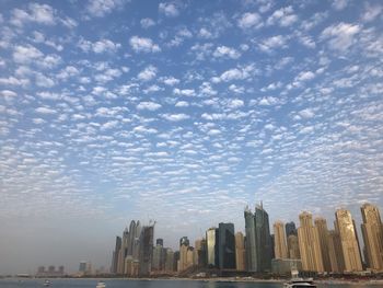 Buildings in city against cloudy sky