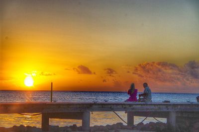 People sitting on beach during sunset