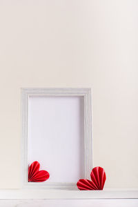 Blank photo frame decorated with diy paper hearts. home decor. vertical view