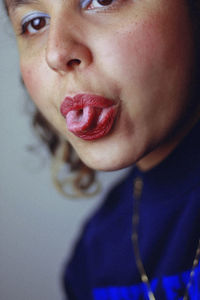 Close-up of young woman sticking out tongue