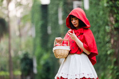 Beautiful woman wearing red hood at forest