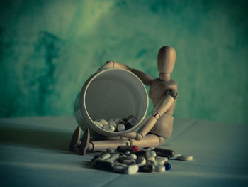 Close-up of figurine on table against wall