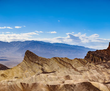 Scenic view of mountains against blue sky