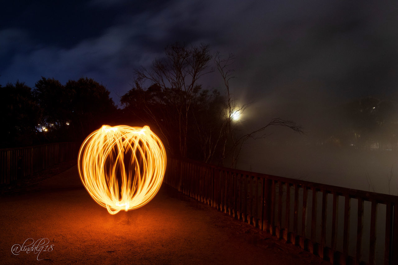 illuminated, glowing, sky, long exposure, night, motion, nature, wire wool, tree, cloud - sky, dusk, railing, light painting, blurred motion, plant, no people, water, outdoors, bridge, land, sparks