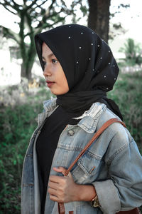 Midsection of woman wearing hat standing on field