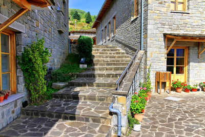 Footpath amidst houses on sunny day