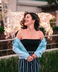 Woman looking away while standing against plants