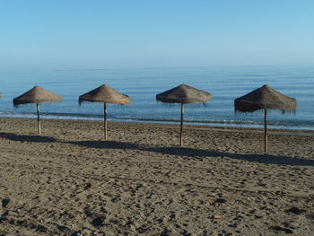 Umbrellas on beach against clear sky