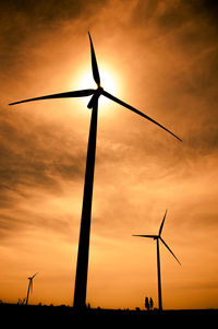 Low angle view of silhouette windmill against sky during sunset