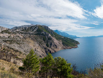 Scenic view of sea and mountains against sky