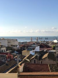 High angle view of buildings by sea against sky