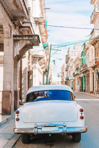 Car on road by buildings in city