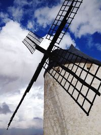 Low angle view of crane against cloudy sky