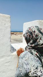 Rear view of man on beach against clear sky