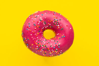 Close-up of multi colored candies against yellow background