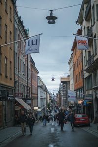 People on street in city against sky