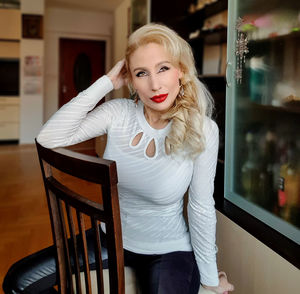 Portrait of fashionable woman sitting on chair at home