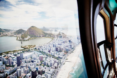 Panoramic view of cityscape by sea against sky