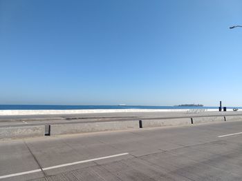 Scenic view of beach against clear blue sky