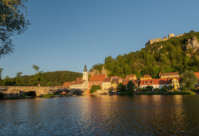 River by buildings against clear sky