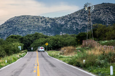 Road amidst trees against sky