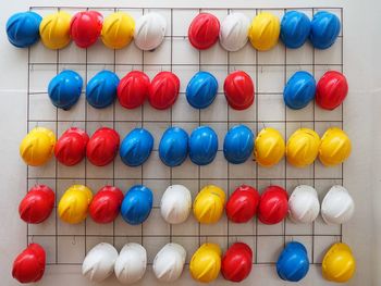 Full frame shot of colorful hardhats hanging on wall