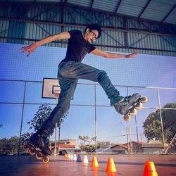 Low angle view of young man inline skating on floor