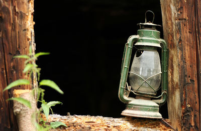 Close-up of old lantern on wooden post