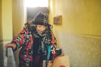 Senior east european disabled woman entering a building with an architectural barrier 