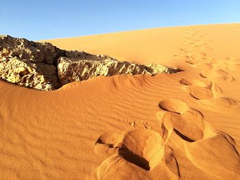 Sand dunes in desert against clear sky