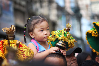 Close-up of cute baby girl sitting on flower