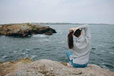 Rear view of woman looking at sea against sky