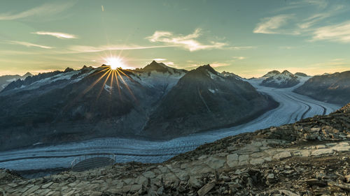 Scenic view of snowcapped mountains against sky during sunset