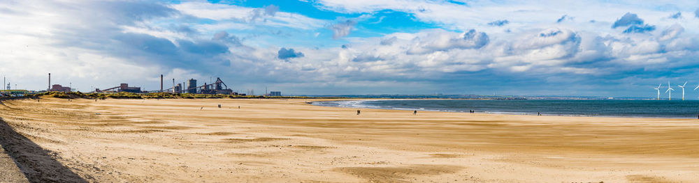 Panoramic view of beach against cloudy sky