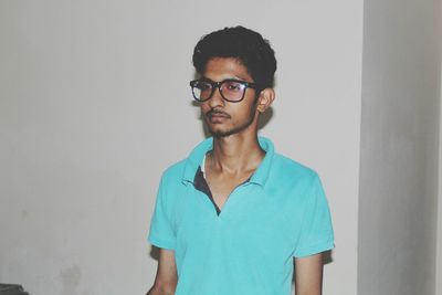 Portrait of young man standing against white background