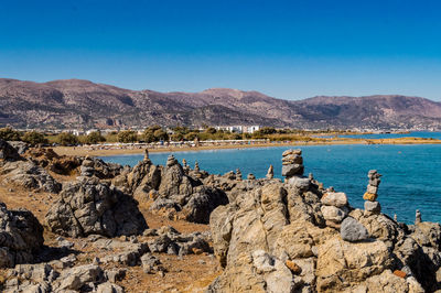 Scenic view of rocks and sea against blue sky