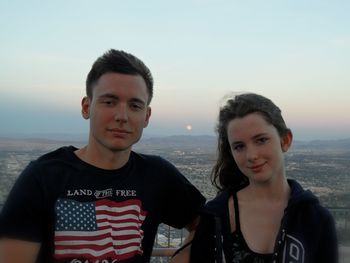 Portrait of smiling young couple at beach against sky