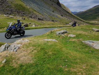 Bicycles parked on land against mountains