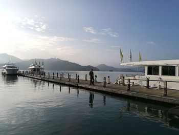 Rear view of pier on sea against sky