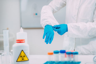 Woman putting protective splash face shield on. laboratory safety equipment.