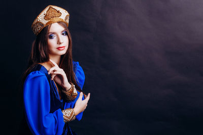 Close-up of beautiful woman in traditional clothing against black background