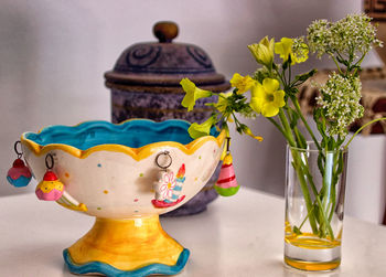 Close-up of colored objects and yellow flowers