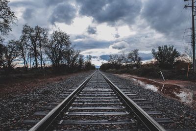 Railroad track against cloudy sky