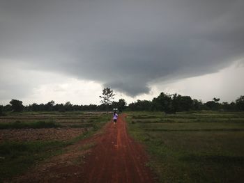 Man standing on agricultural field against sky