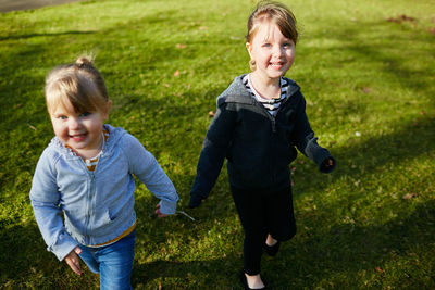 Full length of smiling boy and woman in grass