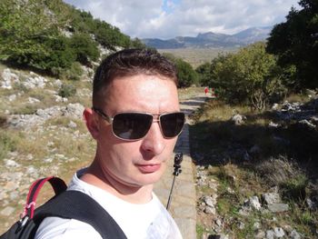 Portrait of man wearing sunglasses against trees