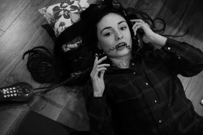 Portrait of young woman lying on bed at home