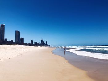 Scenic view of beach against clear blue sky