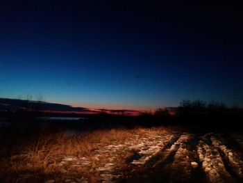 Scenic view of landscape against clear sky at dusk