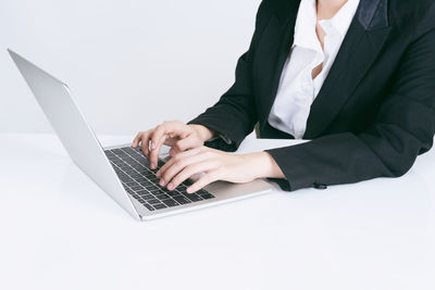 Midsection of man using mobile phone against white background